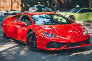 A vibrant red supercar parked outdoors in New Delhi, showcasing luxury and modern design.