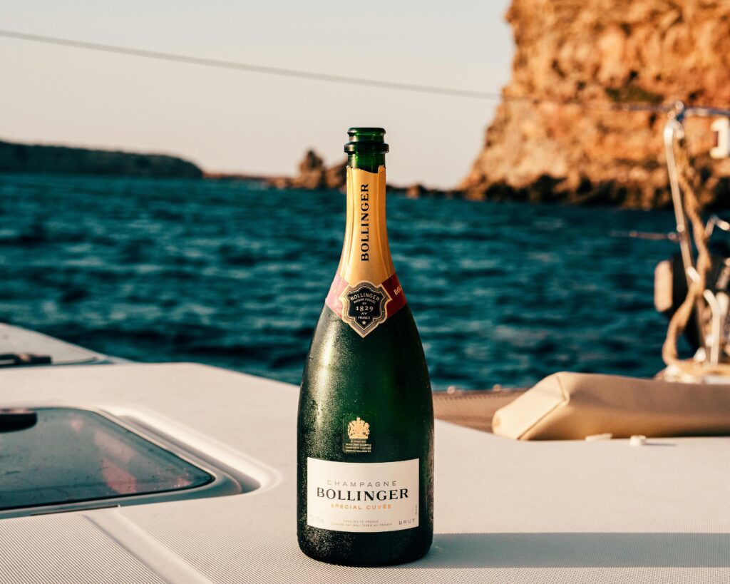 Bollinger champagne bottle on a yacht with Ibiza's ocean view, perfect for celebrations.
