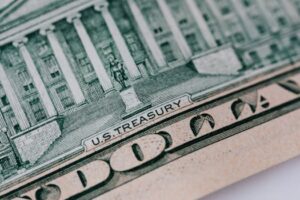 Detailed close-up of the U.S. Treasury text on a dollar bill, showcasing intricate design and financial symbolism.